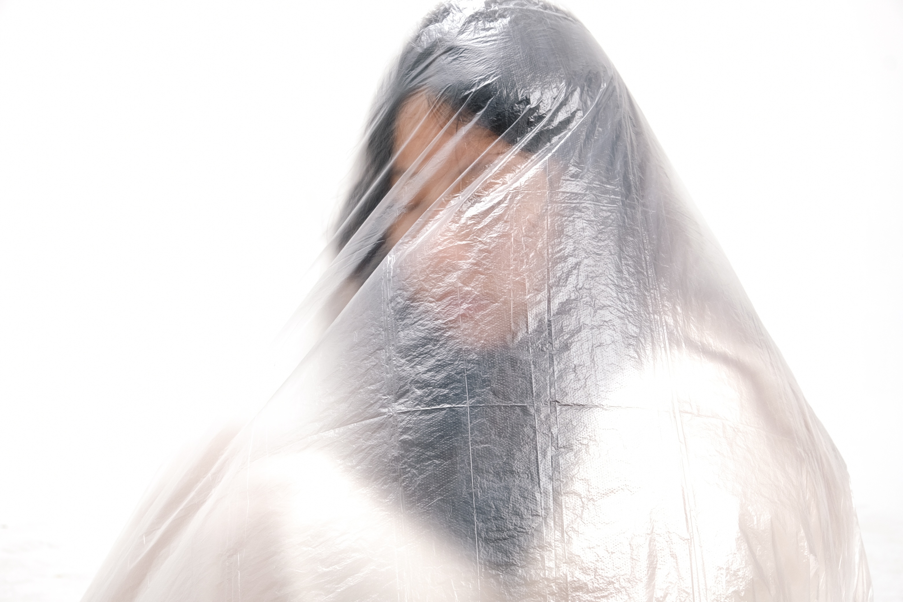 A veiled figure enveloped in translucent material
